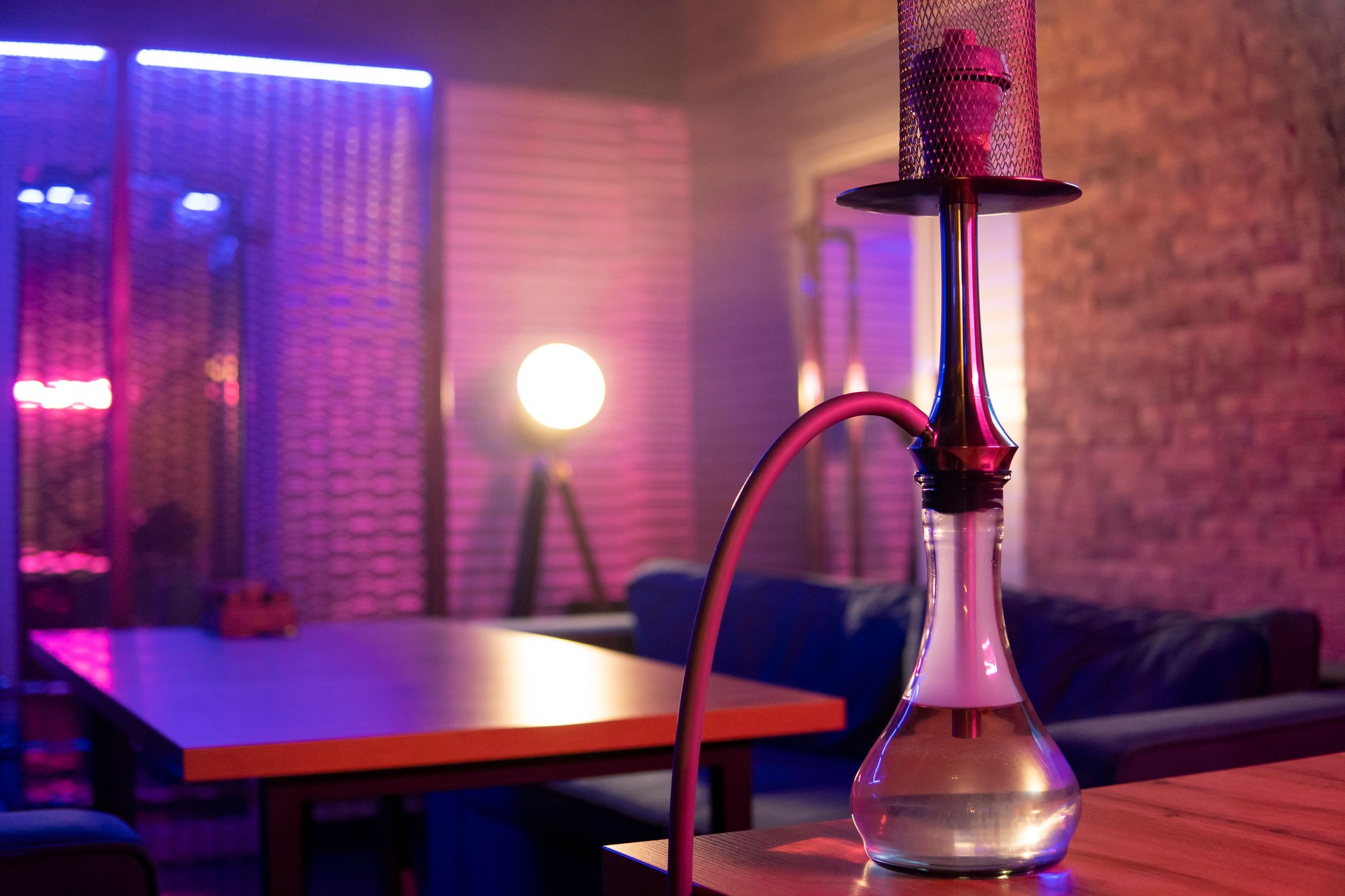 Hookah stands on the table in pink blue neon light